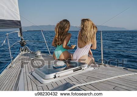 Friends relaxing on deck of sailboat, Italy View Large Photo Image Stock Image - Friends relaxing on deck of sailboat, Italy. Fotosearch