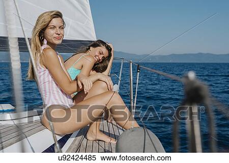 Stock Photography - Friends relaxing on deck of sailboat, Italy. Fotosearch