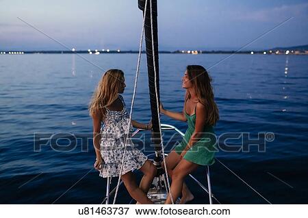 Friends relaxing on sailboat in evening, Italy View Large Photo Image Stock Photo - Friends relaxing on sailboat in evening, Italy. Fotosearch