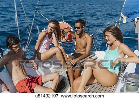 Friends relaxing on sailboat, Italy View Large Photo Image Stock Photo - Friends relaxing on sailboat, Italy. Fotosearch