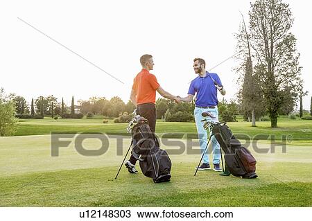Friends shaking hands on golf course View Large Photo Image Stock Image - Friends shaking hands on golf course. Fotosearch