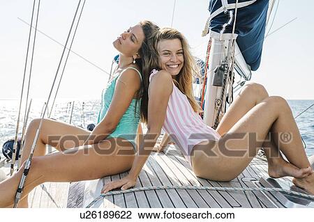 Friends sunbathing on deck of sailboat, Italy View Large Photo Image Stock Image - Friends sunbathing on deck of sailboat, Italy. Fotosearch