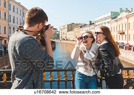 Stock Image - Friends taking photograph in city, Saint Petersburg, Russia. Fotosearch
