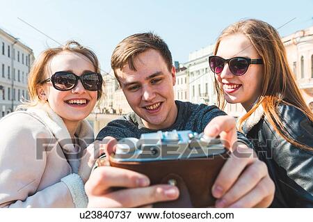Friends taking photograph in city, Saint Petersburg, Russia View Large Photo Image Stock Photo - Friends taking photograph in city, Saint Petersburg, Russia. Fotosearch