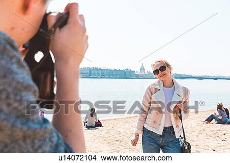 Picture - Friends taking photograph on beach, Saint Petersburg, Russia. Fotosearch