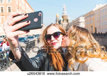 Stock Photograph - Friends taking selfie in city, Saint Petersburg, Russia. Fotosearch