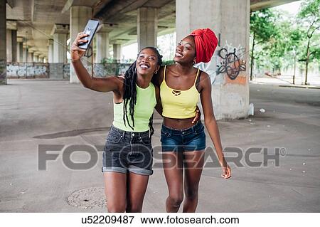 Friends taking selfie in city View Large Photo Image Stock Photo - Friends taking selfie in city. Fotosearch