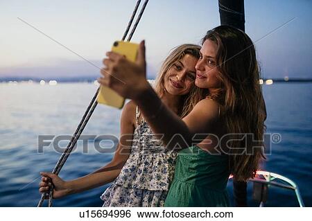 Friends taking selfie on sailboat, Italy View Large Photo Image Stock Photograph - Friends taking selfie on sailboat, Italy. Fotosearch