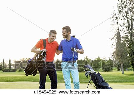 Stock Photography - Friends talking and laughing on golf course. Fotosearch