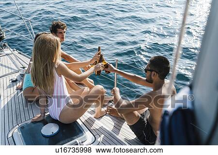 Friends toasting with beer on sailboat, Italy View Large Photo Image Stock Photo - Friends toasting with beer on sailboat, Italy. Fotosearch