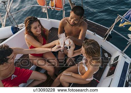 Friends toasting with champagne on sailboat, Italy View Large Photo Image Stock Photo - Friends toasting with champagne on sailboat, Italy. Fotosearch