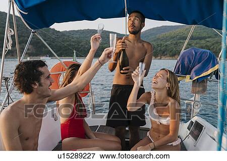 Friends toasting with champagne on sailboat, Italy View Large Photo Image Stock Photo - Friends toasting with champagne on sailboat, Italy. Fotosearch