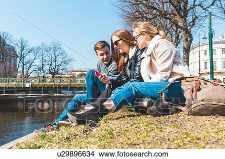 Picture - Friends using smartphone in city, Saint Petersburg, Russia. Fotosearch