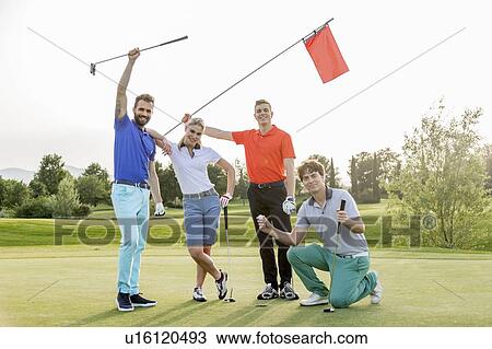 Stock Image - Friends waving flagstick on golf course. Fotosearch