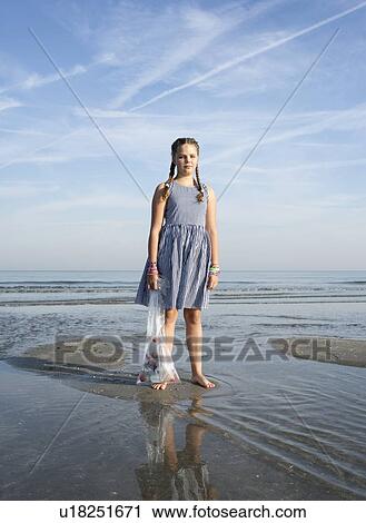 Stock Image - Girl collects plastic waste from beach, Hoek van Holland, Netherlands. Fotosearch