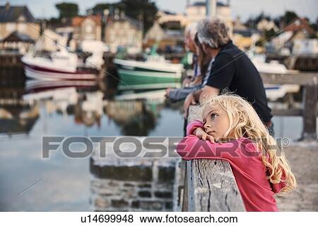 Stock Photo - Girl daydreaming by pier, Normandie, France. Fotosearch