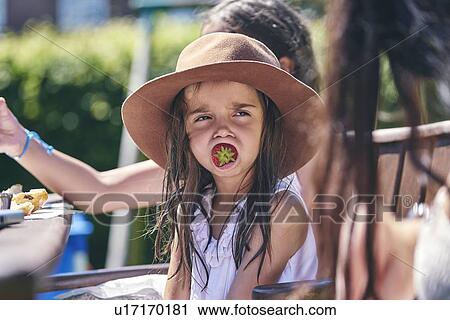 Girl daydreaming with strawberry in mouth View Large Photo Image Stock Image - Girl daydreaming with strawberry in mouth. Fotosearch