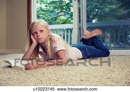 Girl lying on carpet, reading book View Large Photo Image Stock Photography - Girl lying on carpet, reading book. Fotosearch