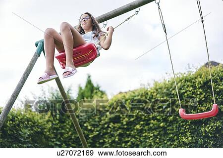 Girl on swing in garden View Large Photo Image Stock Photo - Girl on swing in garden. Fotosearch
