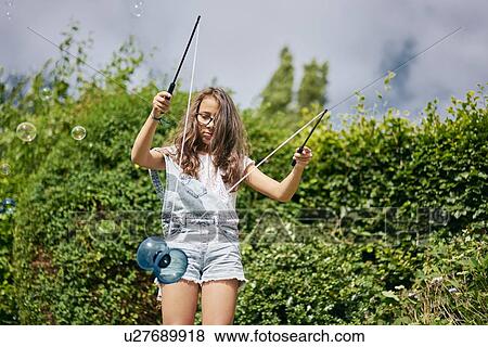 Girl playing with diabolo in garden View Large Photo Image Stock Photo - Girl playing with diabolo in garden. Fotosearch