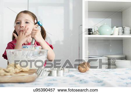 Girl preparing food in bowl, using wire whisk and licking finger View Large Photo Image Stock Photo - Girl preparing food in bowl, using wire whisk and licking finger. Fotosearch