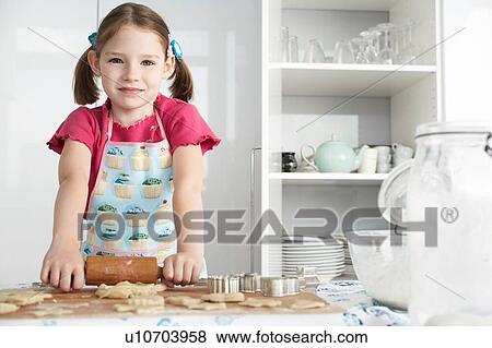 Girl rolling dough in kitchen, portrait View Large Photo Image Stock Photo - Girl rolling dough in kitchen, portrait. Fotosearch