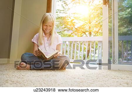 Girl sitting on carpet, reading book View Large Photo Image Stock Photo - Girl sitting on carpet, reading book. Fotosearch