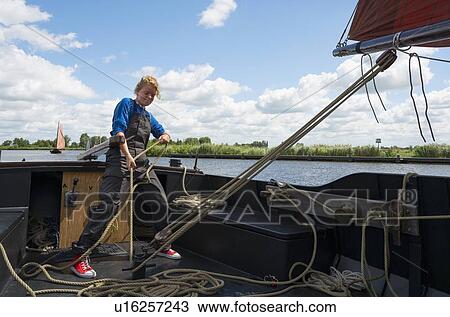 Girl stands at helm of large flat-bottom traditional sailing ship, View Large Photo Image Stock Image - Girl stands at helm of large flat-bottom traditional sailing ship,. Fotosearch