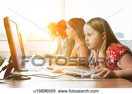 Girl with Down syndrome using computer at school classroom View Large Photo Image Stock Photo - Girl with Down syndrome using computer at school classroom. Fotosearch
