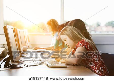 Stock Photo - Girl with Down syndrome using computer at school. Fotosearch