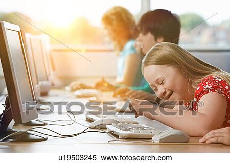 Stock Photography - Girl with Down syndrome using computer at school. Fotosearch