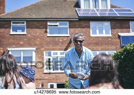 Stock Photography - Grandfather playing with grandchildren in inflatable pool. Fotosearch
