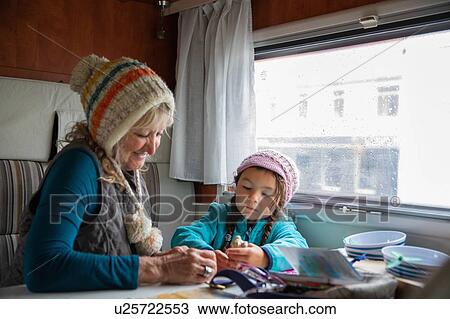 Stock Image - Grandmother and granddaughter playing in a campervan. Fotosearch