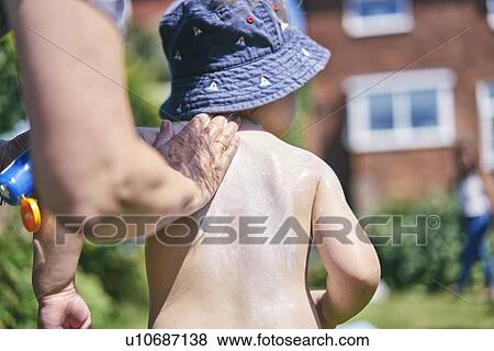 Grandmother putting sun lotion on grandson View Large Photo Image Stock Photo - Grandmother putting sun lotion on grandson. Fotosearch