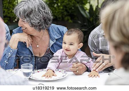 Grandmother with granddaughter on lap at outdoor family lunch, Florence, Italy View Large Photo Image Stock Photo - Grandmother with granddaughter on lap at outdoor family lunch, Florence, Italy. Fotosearch