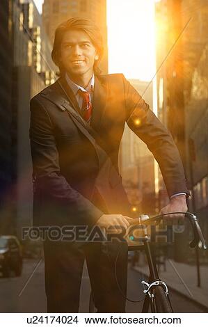 Handsome brunette business man commuting to work by bicycle wearing suit and tie View Large Photo Image Picture - Handsome brunette business man commuting to work by bicycle wearing suit and tie. Fotosearch