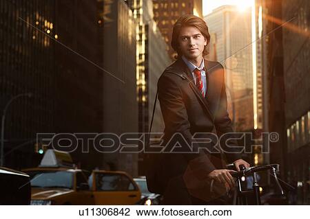 Handsome brunette business man commuting to work by bicycle wearing suit and tie View Large Photo Image Stock Image - Handsome brunette business man commuting to work by bicycle wearing suit and tie. Fotosearch