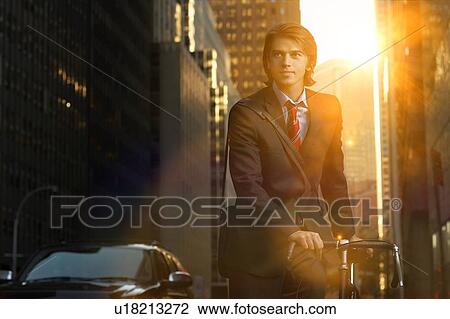 Handsome brunette business man commuting to work by bicycle wearing suit and tie View Large Photo Image Stock Image - Handsome brunette business man commuting to work by bicycle wearing suit and tie. Fotosearch