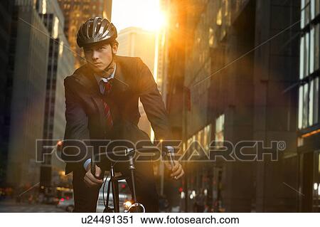 Handsome brunette business man commuting to work by bicycle wearing suit and tie View Large Photo Image Stock Image - Handsome brunette business man commuting to work by bicycle wearing suit and tie. Fotosearch