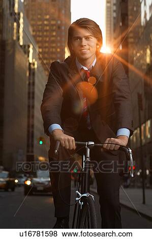 Handsome brunette business man commuting to work by bicycle wearing suit and tie View Large Photo Image Stock Photo - Handsome brunette business man commuting to work by bicycle wearing suit and tie. Fotosearch