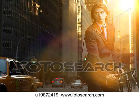 Handsome brunette business man commuting to work by bicycle wearing suit and tie View Large Photo Image Stock Photo - Handsome brunette business man commuting to work by bicycle wearing suit and tie. Fotosearch