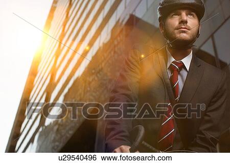 Handsome brunette business man commuting to work by bicycle wearing suit and tie View Large Photo Image Stock Photograph - Handsome brunette business man commuting to work by bicycle wearing suit and tie. Fotosearch