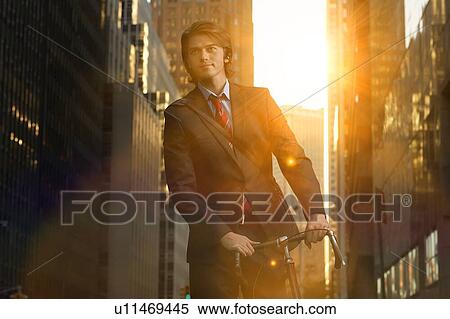 Handsome brunette business man commuting to work by bicycle wearing suit and tie View Large Photo Image Stock Photography - Handsome brunette business man commuting to work by bicycle wearing suit and tie. Fotosearch