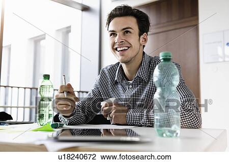 Happy businessman working in office View Large Photo Image Stock Image - Happy businessman working in office. Fotosearch