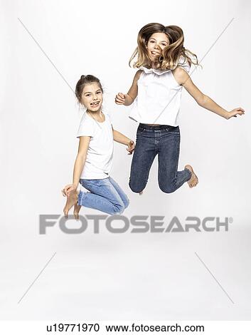 Happy girls jumping, white background View Large Photo Image Stock Image - Happy girls jumping, white background. Fotosearch