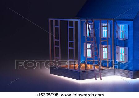Stock Photo - Illuminated model house with ladder and extension. Fotosearch