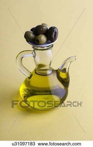 Stock Image - Jug of olive oil with olives. Fotosearch