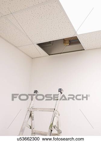 Stock Image - Ladder in Below Open Ceiling Panel in Empty Office. Fotosearch
