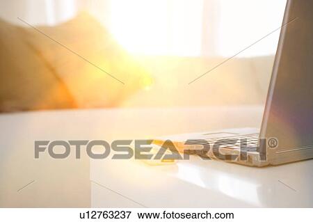 Stock Photo - Laptop and cell phone on table. Fotosearch