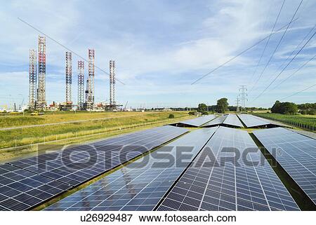 Stock Photo - Large solar farms, disused oil rigs stored in Vlissingen harbour, Nieuwdorp, Zeeland, Netherlands. Fotosearch